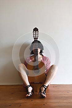 A woman sitting with a guitar