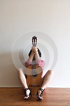 A woman sitting with a guitar photo