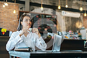 Woman  sitting happily drinking coffee in cafe shop and labtop