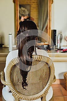 Woman sitting on her back in retro room with a braid in her hair