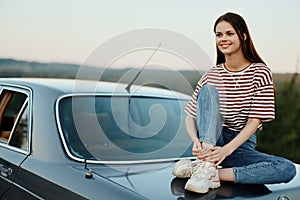 Woman sitting in her car on a road trip and relaxing, lifestyle on the road