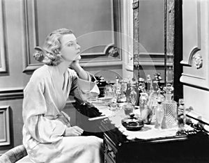 Woman sitting at her vanity looking into the mirror