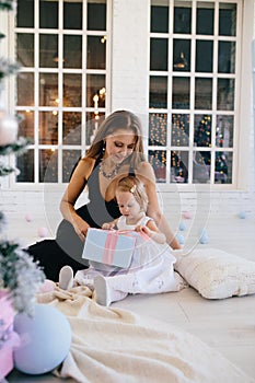 Woman sitting with his little daughter and a Christmas gift box