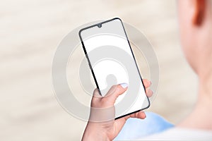 Woman sitting and holding blank screen mock up mobile phone