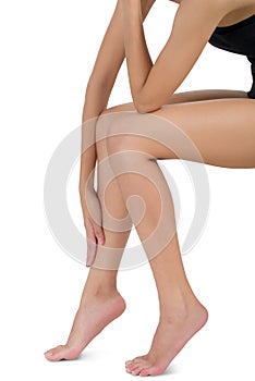 Woman sitting and holding her beautiful Healthy long leg with massaging shin in pain area.
