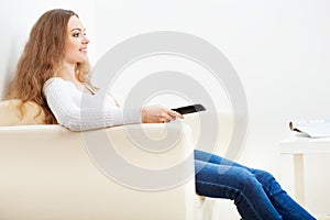 Woman sitting and holding remote from tv