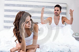 Woman sitting while husband shouting at her