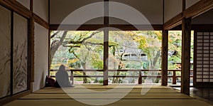 Woman sitting in komyozenji temple rear rock garden