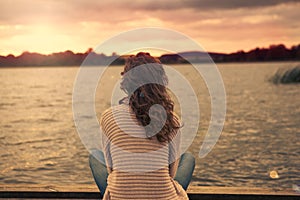 Woman is sitting at the lake