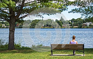 Woman sitting by a lake in Massachusetts