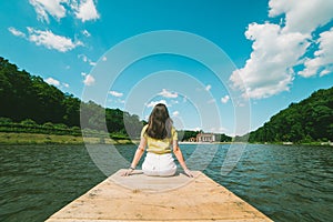 Woman sitting on a lake pier