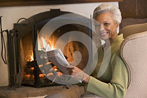 Woman sitting in living room by fireplace