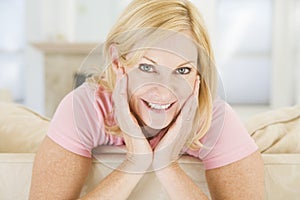 Woman sitting in living room smiling