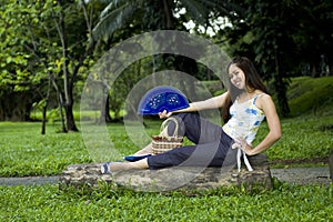 Woman sitting on log with open fan