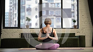 Woman Sitting in Lotus Pose and Meditating with Open Hands. Yoga Female Practicing Yoga Meditation Exercise on the Mat