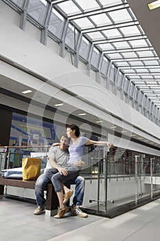 Woman Sitting On Man's Lap In Shopping Center