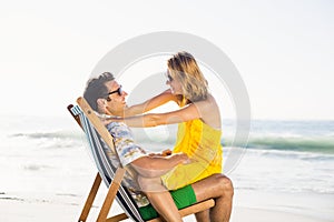 Woman sitting on mans lap at beach