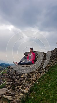 Griffen - Woman sitting on medieval stone walls. Scenic view of castle ruins Burgruine Griffen in Voelkermark photo