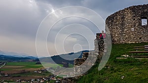 Griffen - Woman sitting on medieval stone walls. Scenic view of castle ruins Burgruine Griffen in Voelkermark photo