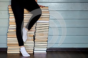 Woman sitting on mountain of books archives.