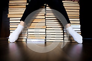 Woman sitting on mountain of books archives.