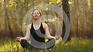 Woman sitting namaste yoga pose in spiritual relaxation serenity and meditation in the forest