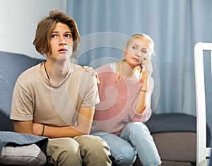 Woman sitting near her sad son and calling to doctor