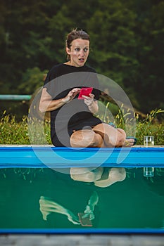 Woman sitting next to a pool