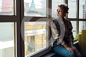 Woman sitting next to a window