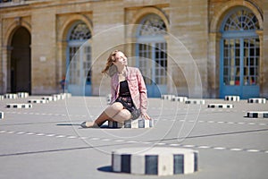 Woman sitting on one of the Colonnes de Buren in Paris photo