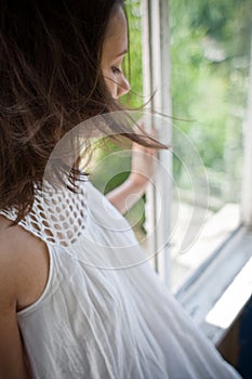 Woman sitting on open window