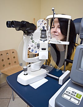Woman sitting in optician machine