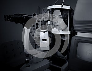 Woman sitting in optician machine