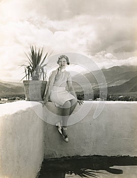 Woman sitting on outdoor ledge