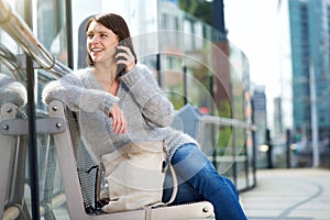 Woman sitting outside in the city listening to cell phone
