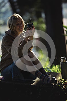 A woman sitting in the park with a cup of Mate.
