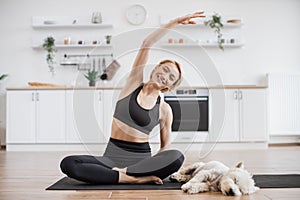 Woman sitting in Parsva Sukhasana during doggy bedtime