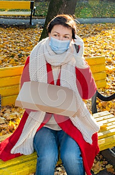 Woman sitting phone box pizza bench park street autumn delivery mask protective