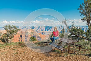 Woman sitting on Picnic Table at The Grand Caynon