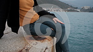 Woman sitting on pier admire picturesque landscape of Montenegro.