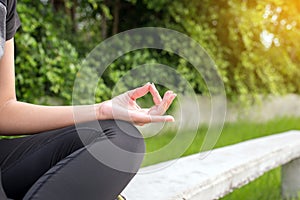 Woman sitting practicing doing yoga exercise,workout after waking up at public park,Healthy and lifestyle concept