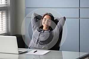 Woman sitting put hands behind head enjoy repose during workday