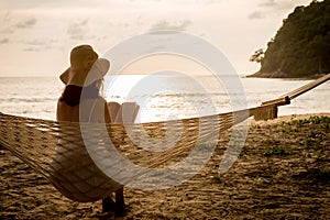 Woman sitting and reading in hammock.