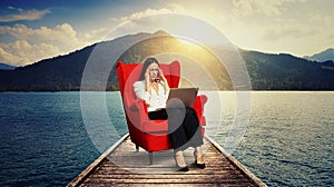 Woman sitting on the red chair on wood moorage photo