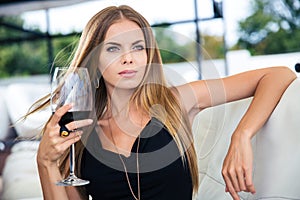 Woman sitting at the restaurant with glass of red wine