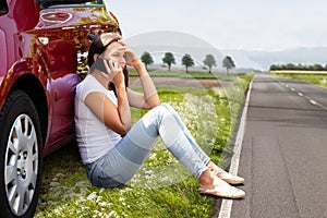 Woman Sitting On Road Near Breakdown Car