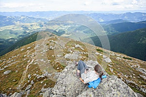 Woman sitting on a rock and drinking tea photo