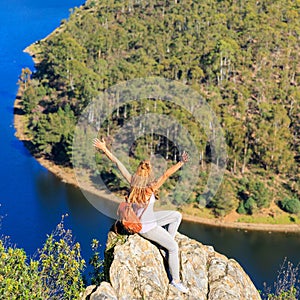 Woman sitting on rock looking at meander