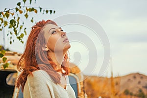 Woman sitting on rusty old classic truck.