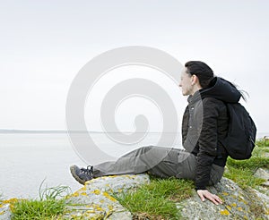 Woman sitting on sea cliff